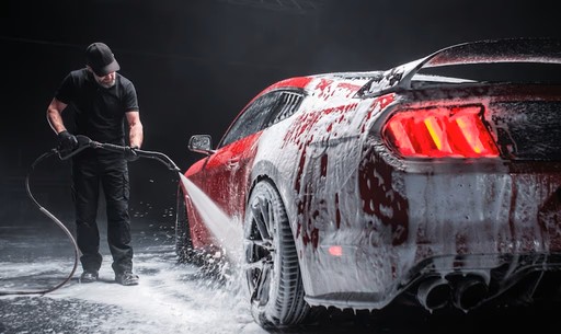 Red Ford Mustang covered in thick foam during a hand wash